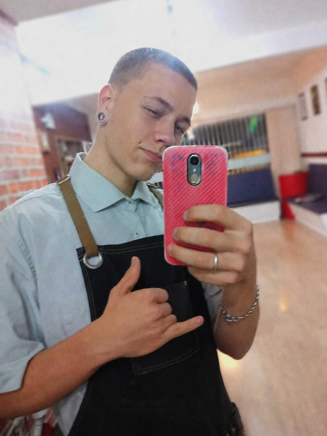 Kauã jovem usando seu primeiro uniforme de barbeiro